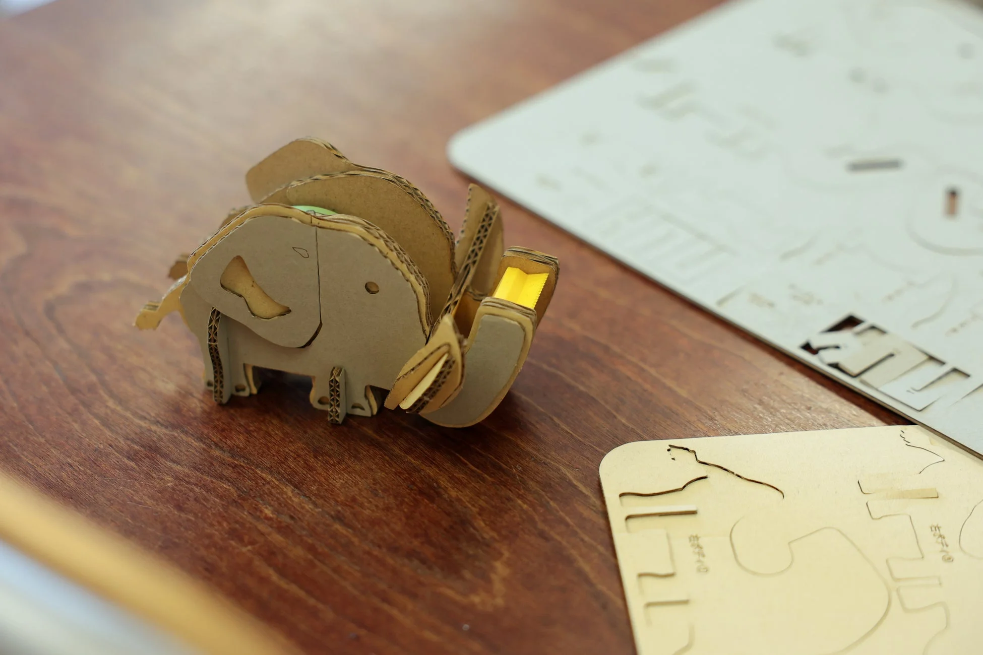木のテーブルの上に、段ボールで作られた可愛らしいゾウの模型