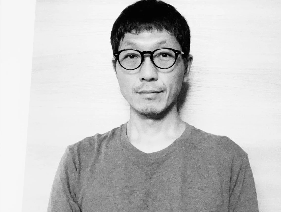 モノクロで撮影された眼鏡をかけたアジア系の男性のポートレート