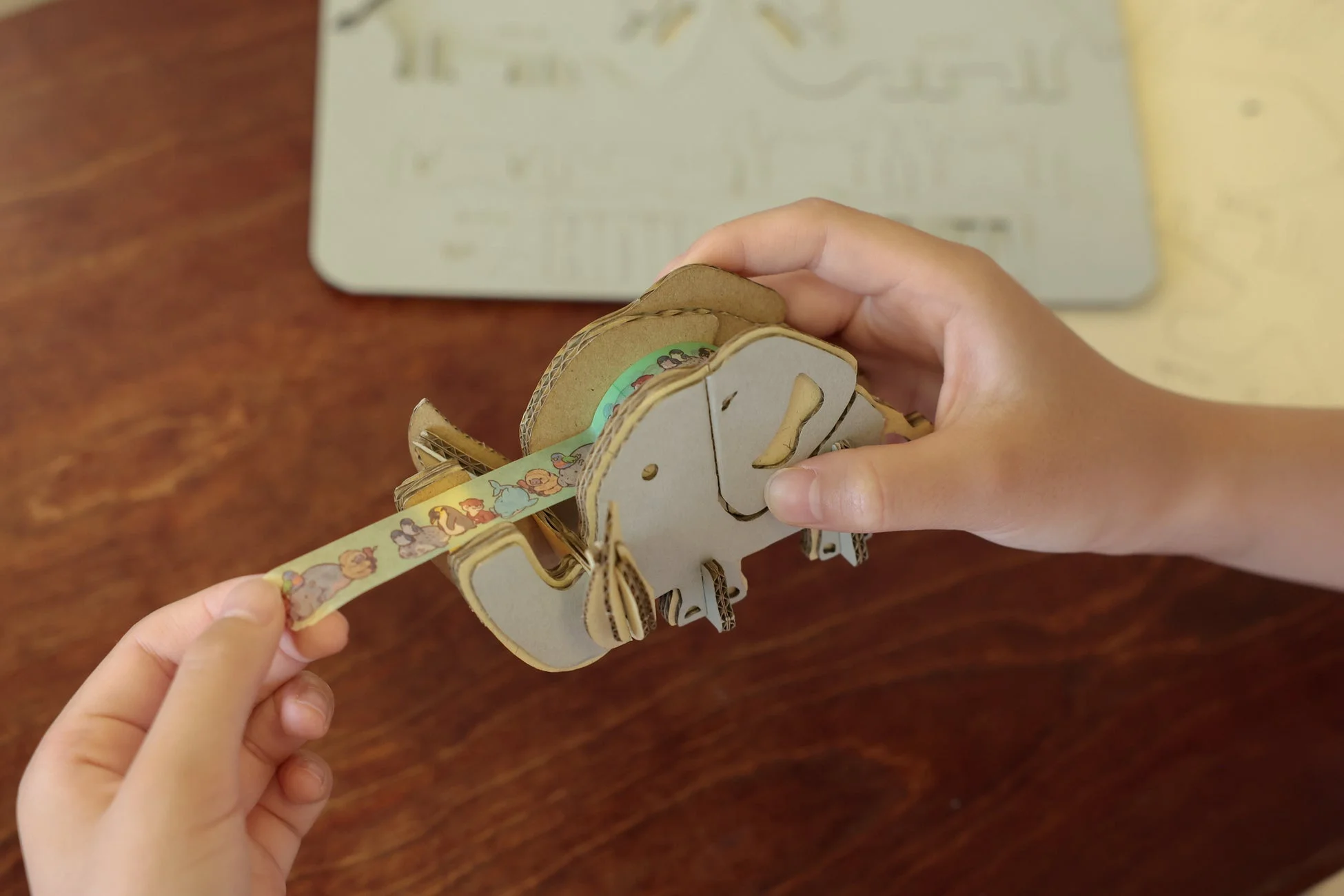 段ボールで作られたゾウの工作を両手で持っている様子