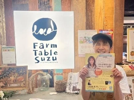Farm Table Suzuのポスターを持つ笑顔の女性