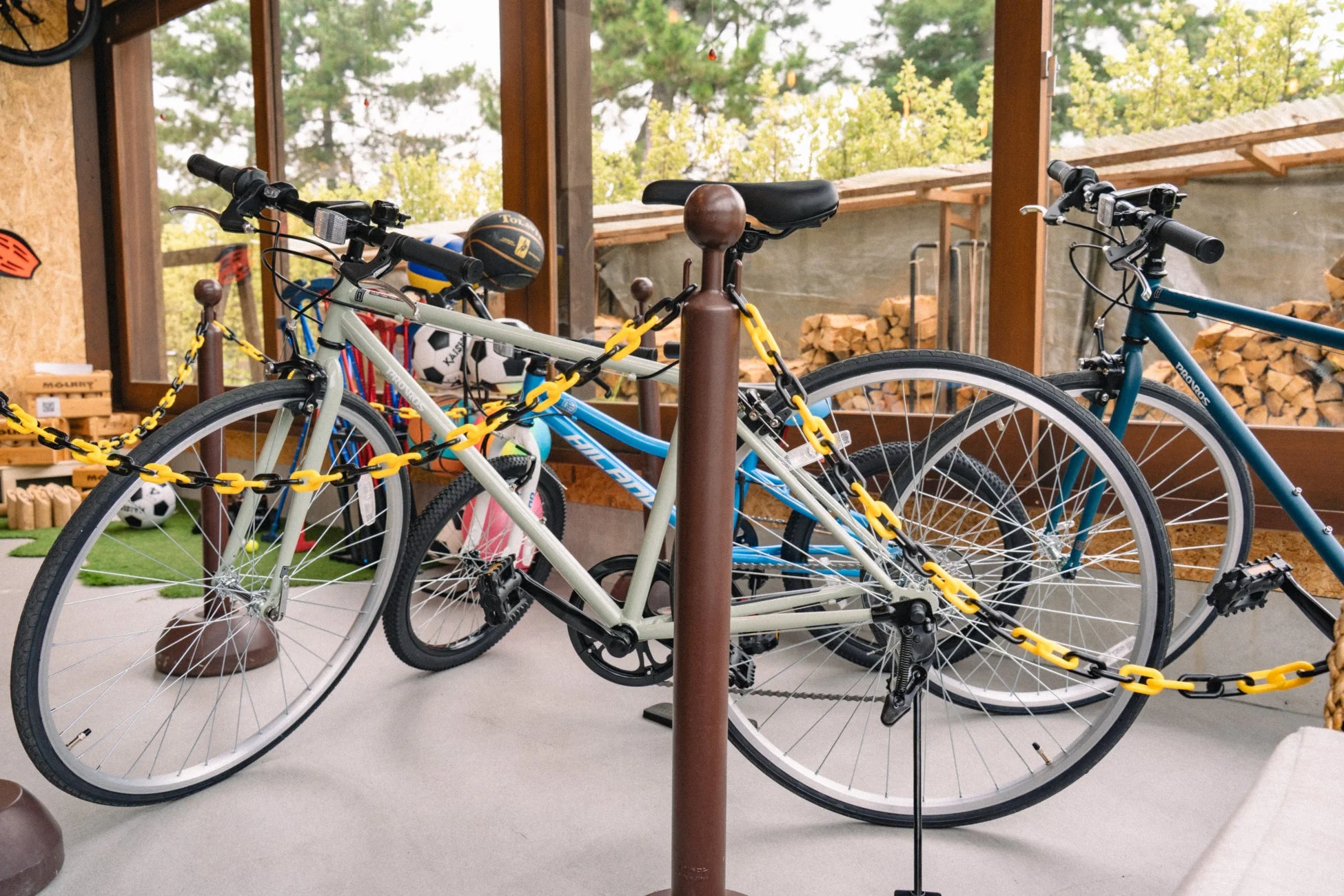 複数の自転車がチェーンで施錠され、屋外の柱に駐輪されている様子