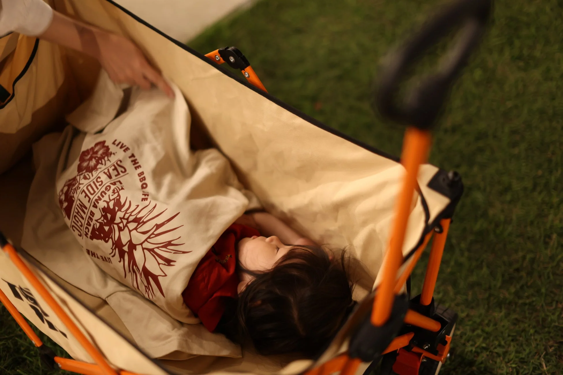 屋外のワゴンで眠る子供