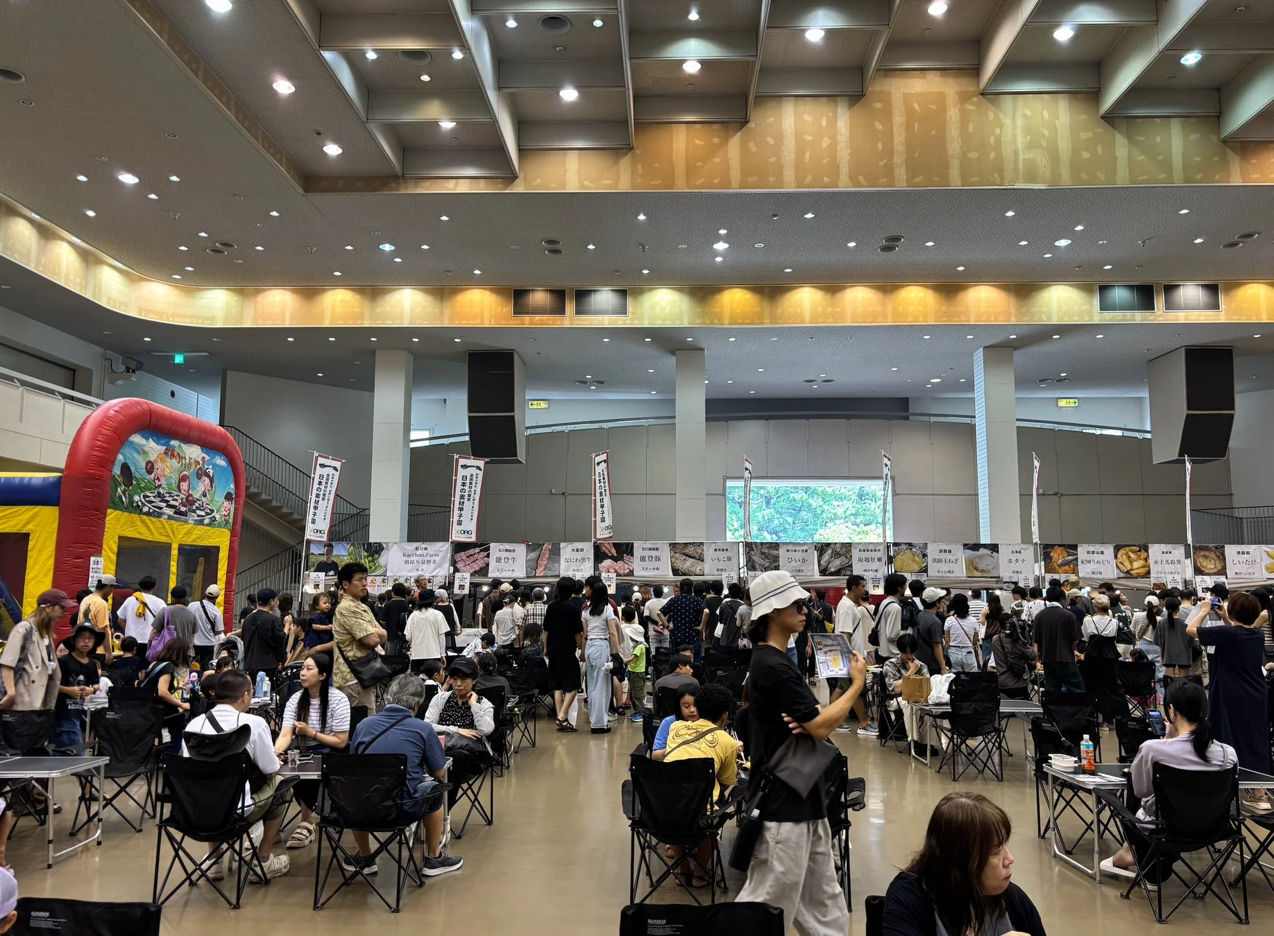 多くの人々で賑わう屋内イベント会場の様子。食品や地方特産品のブースが多数出展されている。