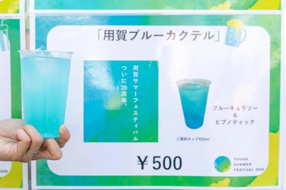 青いカクテルが入ったカップが手で持たれており、ブルーキュラソーとヒプノティックを使用していること、価格が500円であることが示されています。