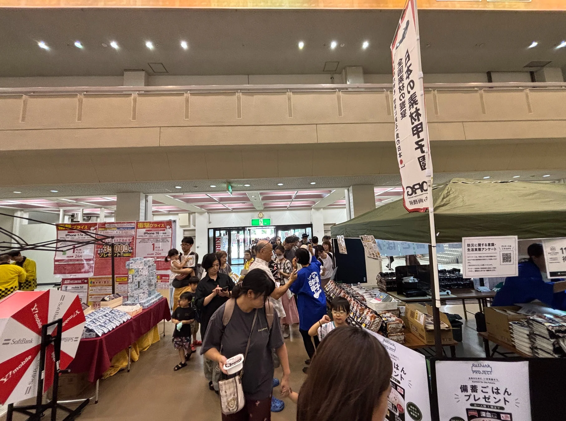 商業施設内で開催されているイベントの様子。防災関連のブースがあり、備蓄ご飯プレゼントの案内が見える。