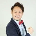 蝶ネクタイとジャケットを着用した笑顔の男性