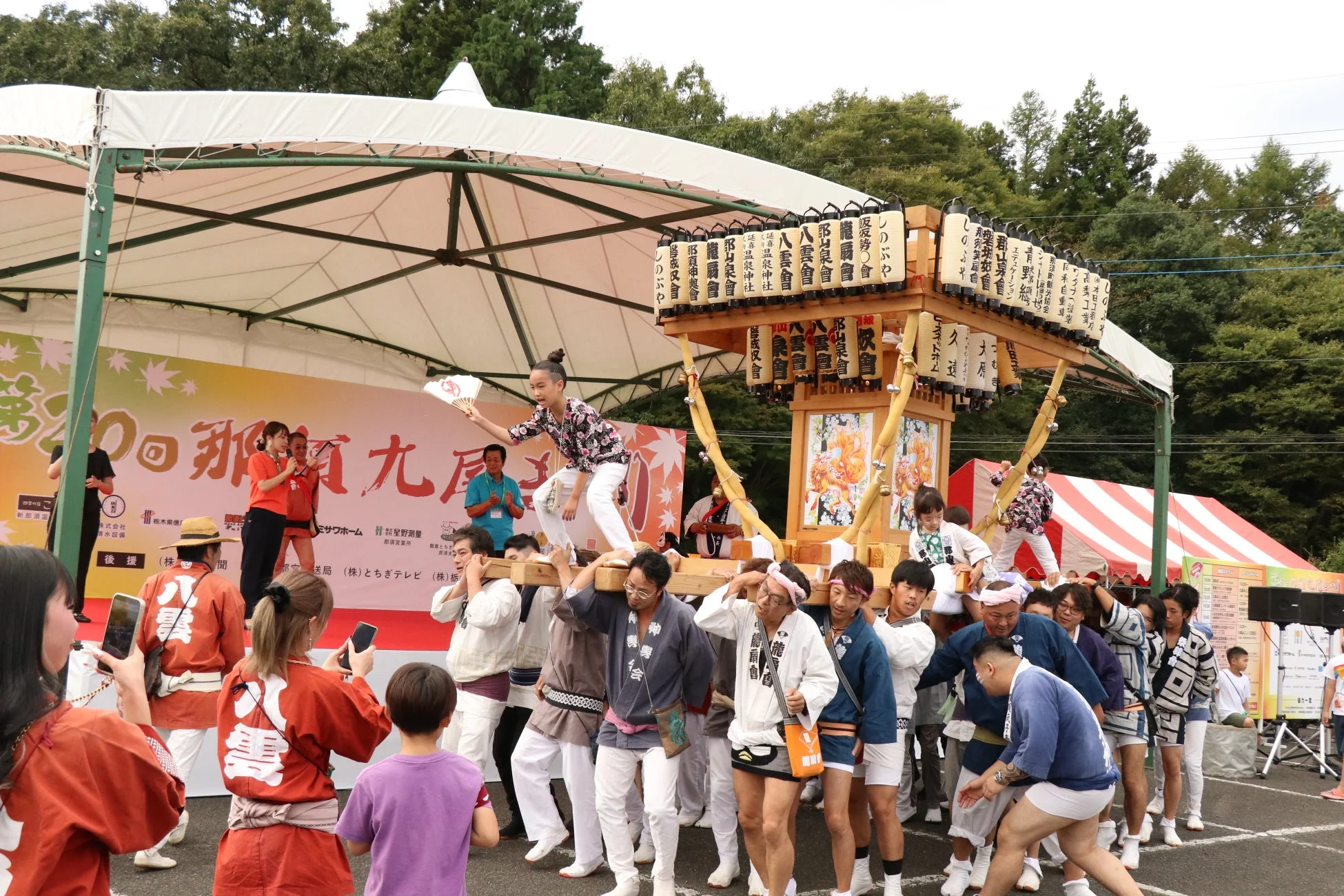 神輿を担ぎ練り歩く人々と観客