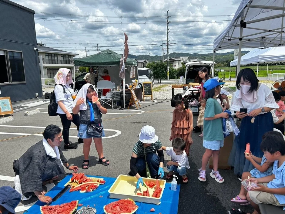 屋外イベントでスイカを楽しむ人々