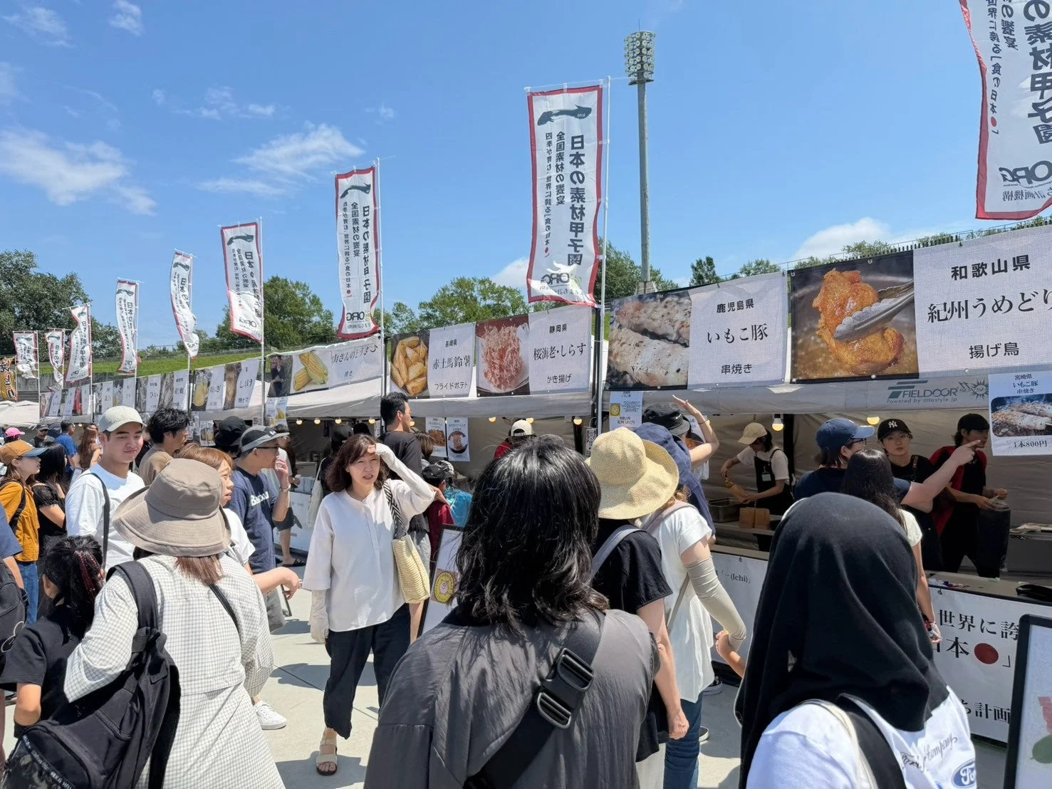 フードフェスティバル、屋外イベント、屋台、日本食、祭り、賑わい、夏、青空、揚げ物、串焼き、ご当地グルメ、B級グルメ、フライドポテト、とうもろこし、鶏肉、豚肉、海老、しらす