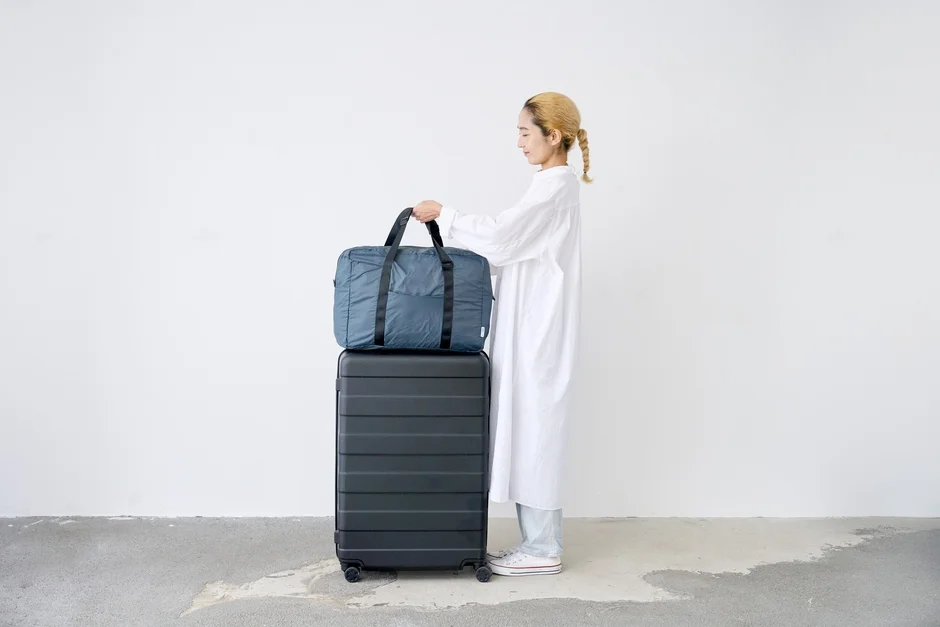 女性がスーツケースの上にNANOPLUS FIT CARRY ON BAGを置いている