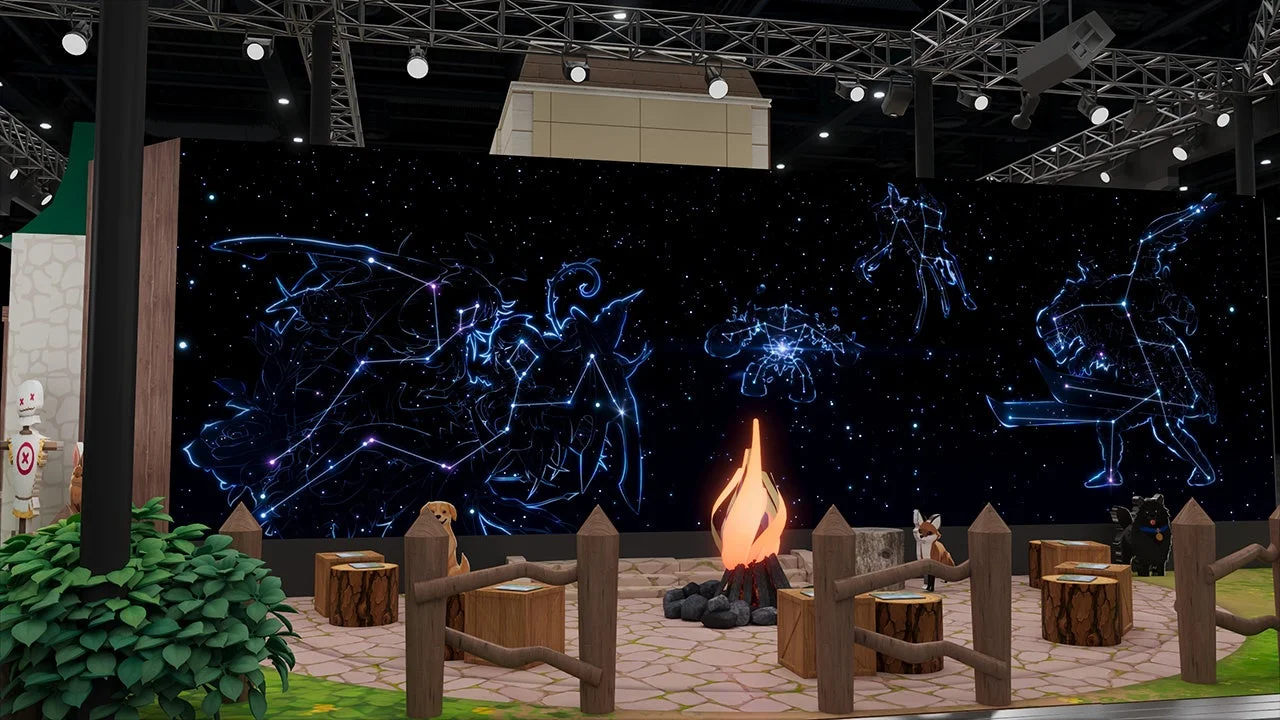 星空と星座のデジタルディスプレイを背景に、キャンプファイヤーや切り株の椅子、動物のオブジェが配置された幻想的な展示ブース