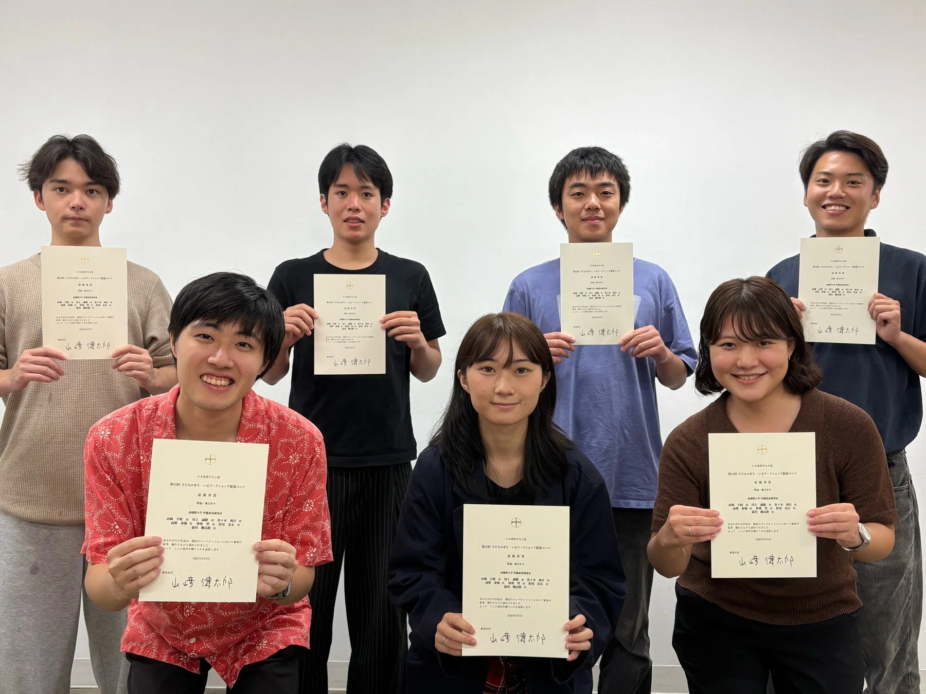 賞状を手に笑顔で写る学生たちの集合写真