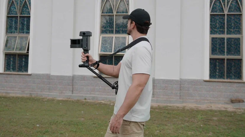男性がカメラを構えている屋外写真