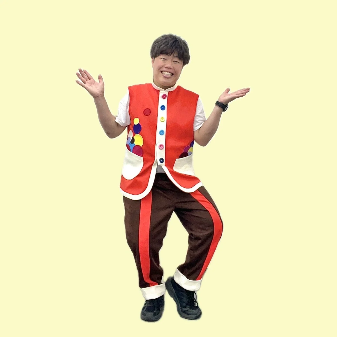カラフルな衣装を着て笑顔でポーズをとる男性