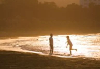 夕焼けの海辺に立つ人物のシルエット