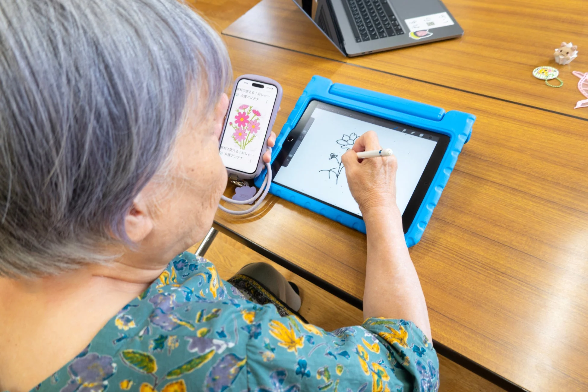 高齢の女性がタブレットでデジタルお絵描き
