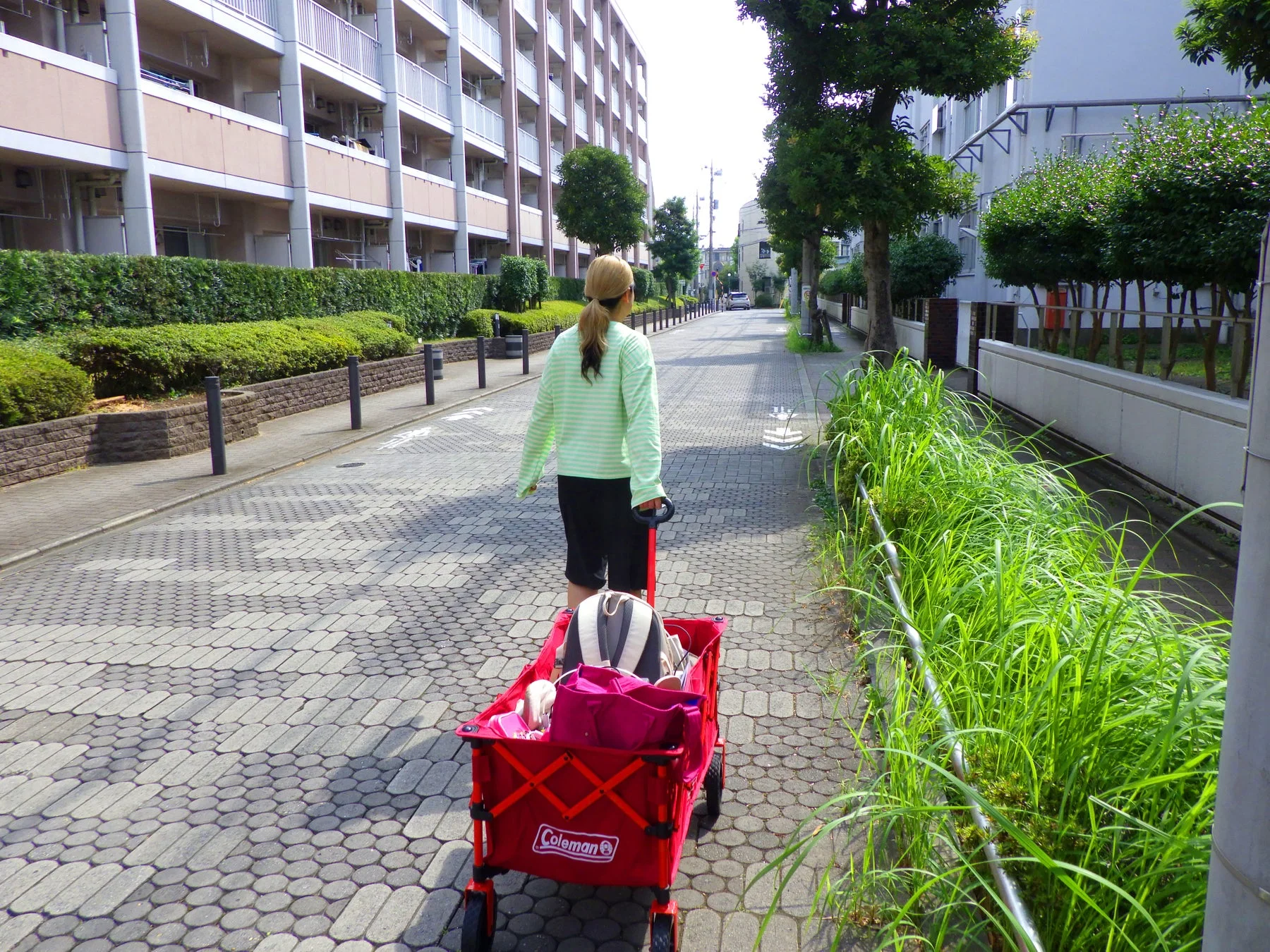 女性がワゴンを引いて歩く