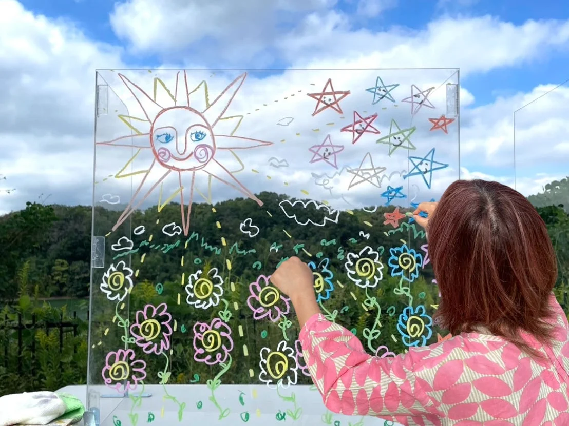 アクリル板にお絵描きする女性
