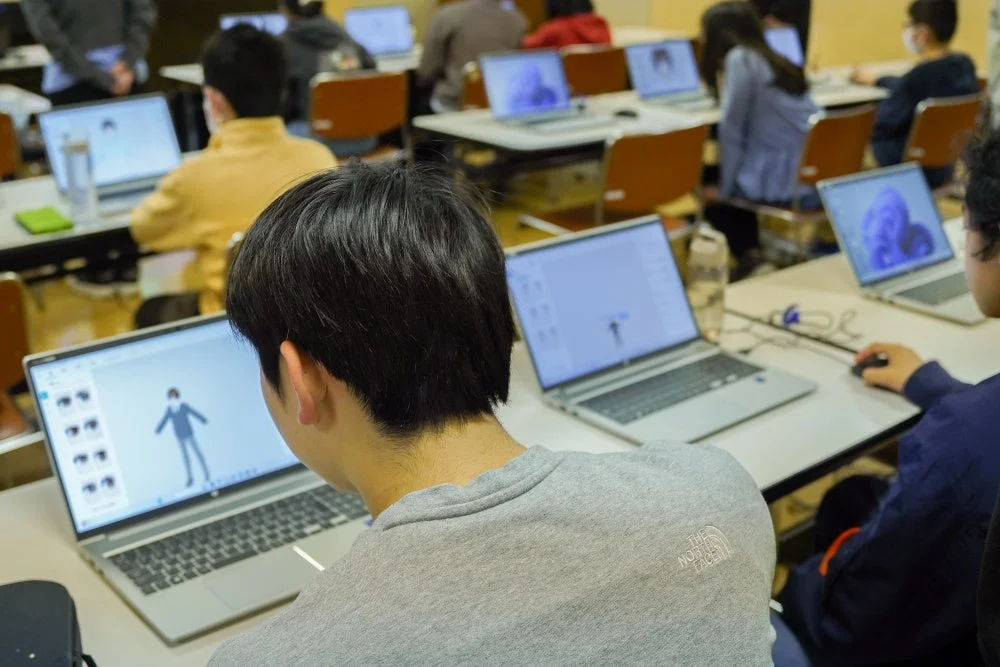 教室で学生がノートパソコンでデジタル制作をしている様子