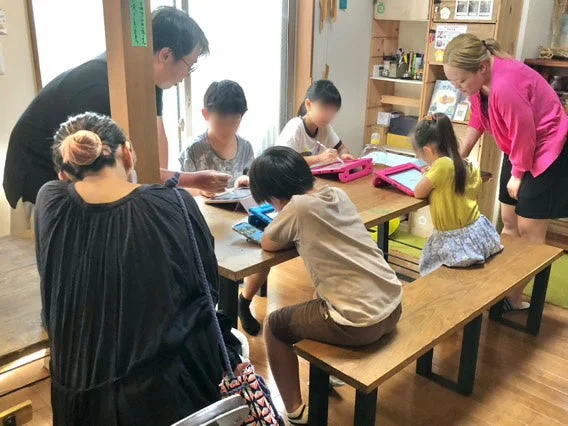 子供たちが大人の指導のもとタブレットで学習