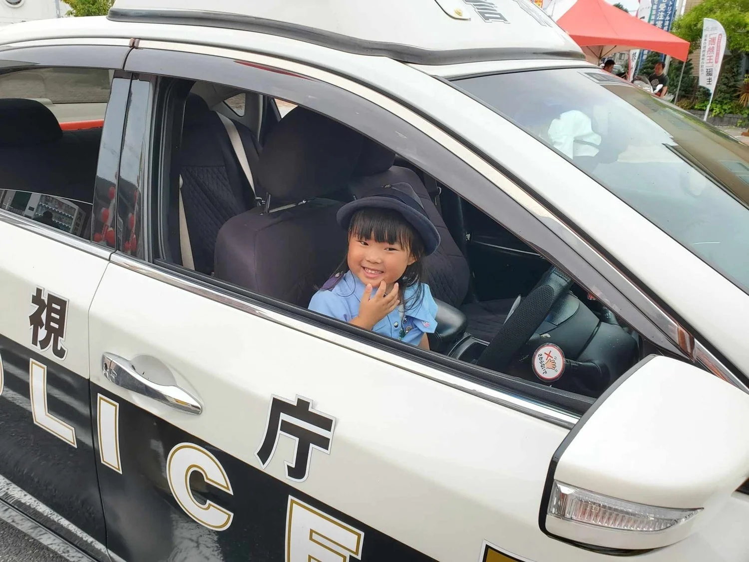 パトカーと警察官の制服を着た子供